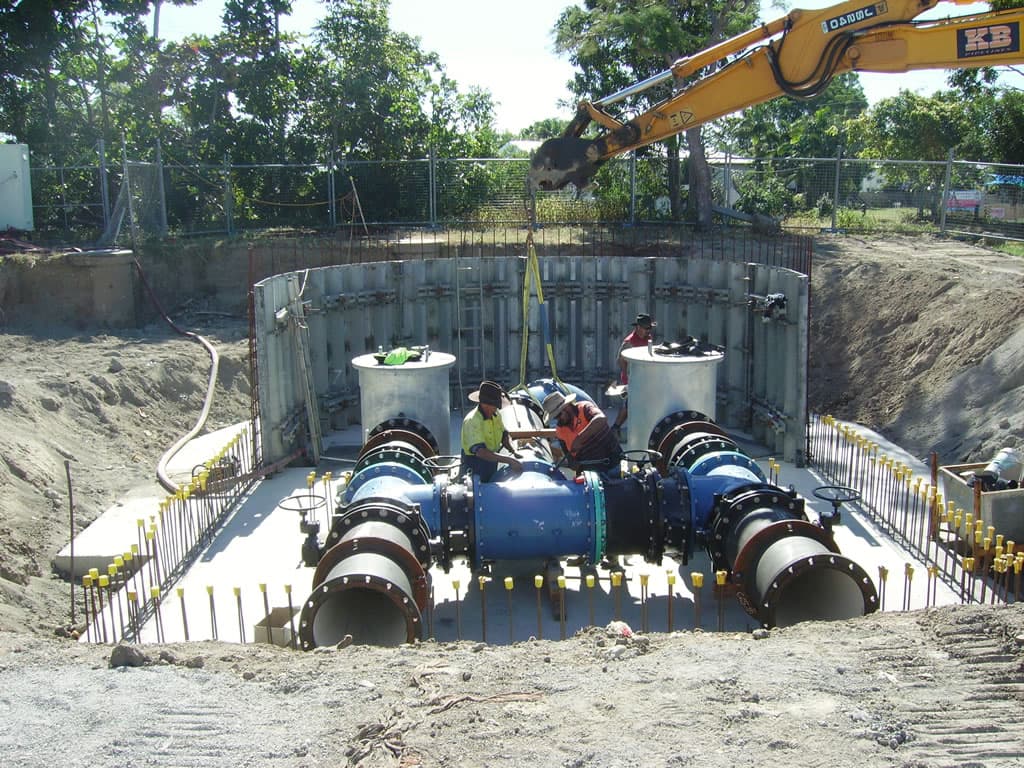 Workers installing large valves and pipework inside the caisson at the Campbell Street Pump Station