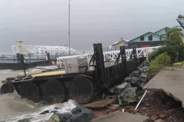 Storm-damaged pontoon and seawall at Shute Harbour in rough seas