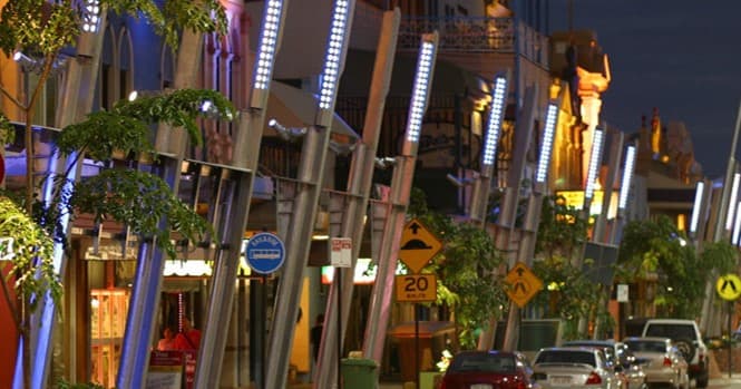 A street in the Townsville CBD at night, lined with lit poles and shopfronts